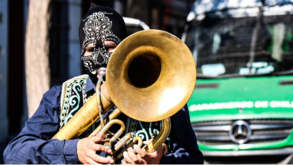 Músico encapuchado de la banda que salió del Museo del Estallido Social (FOTO: Sofía Concha)